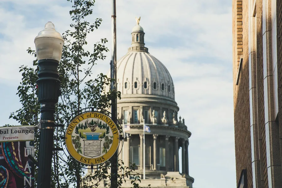 Iconic dome of Boundary County Courthouse set against clear sky, with street sign in foreground.