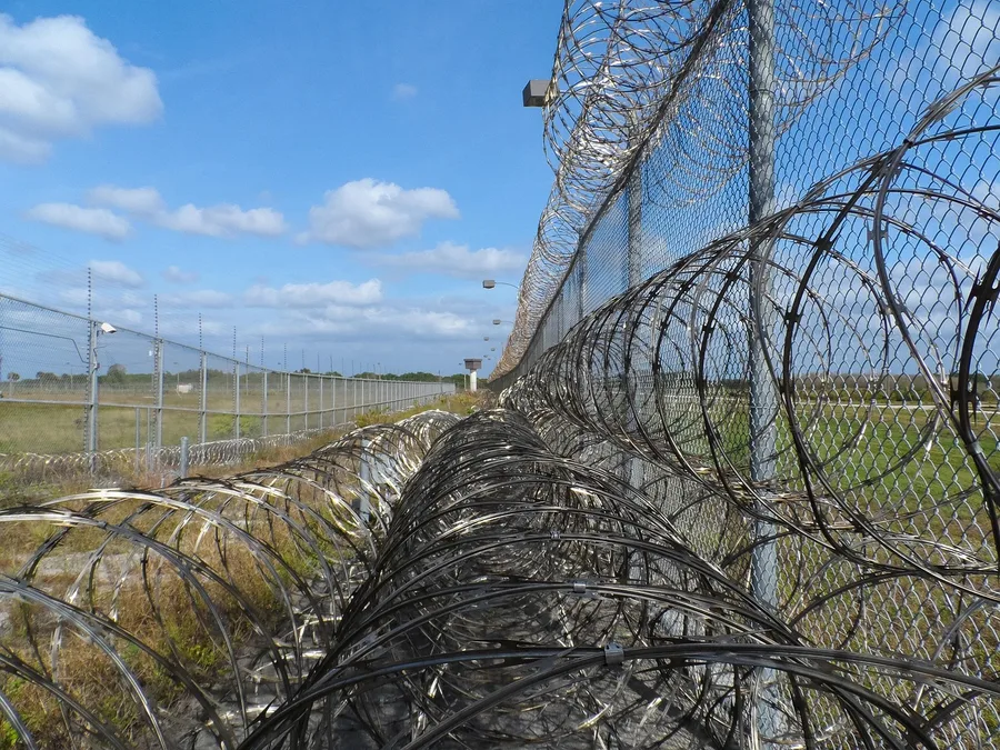 prison fence, razor ribbon, wire, metal, fence, barbed, barb, prison, spikes, barbwire, captive, captured, arrested, prisoner, inmate, detained, jail, protected, immokalee, florida, corrections, correctional institution, justice, law enforcement, police, blue police, blue law, blue prison, blue metal, prison, prison, prison, prison, prison, inmate, jail, jail