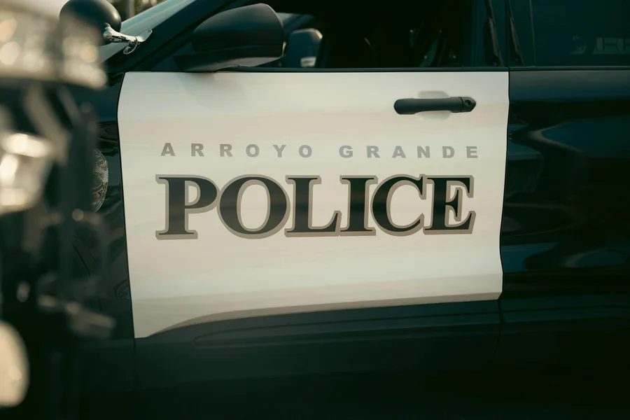 Close-up view of Arroyo Grande Police car door, showcasing bold text and design.