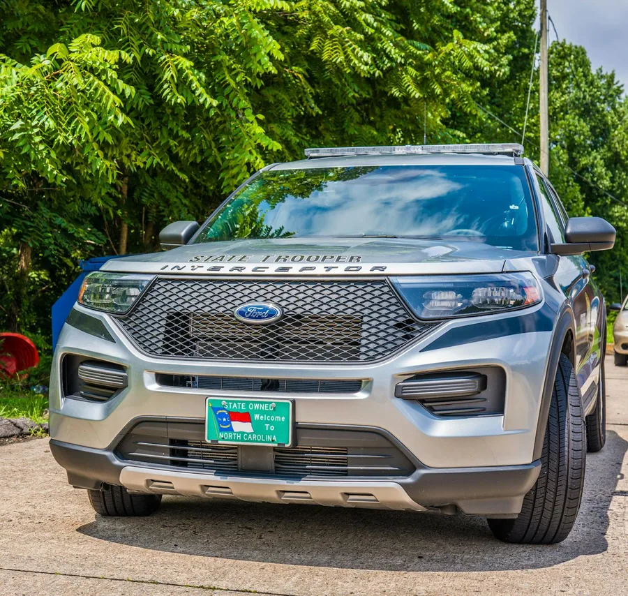A state trooper SUV parked outdoors in summer weather, showcasing law enforcement presence.