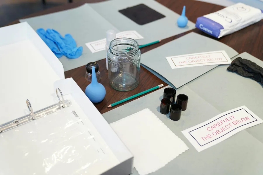 Organized forensic tools including gloves and jars on a table for investigation.