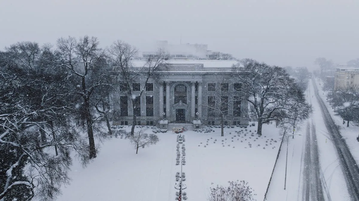 Historic courthouse blanketed in snow, captured on a serene winter day.
