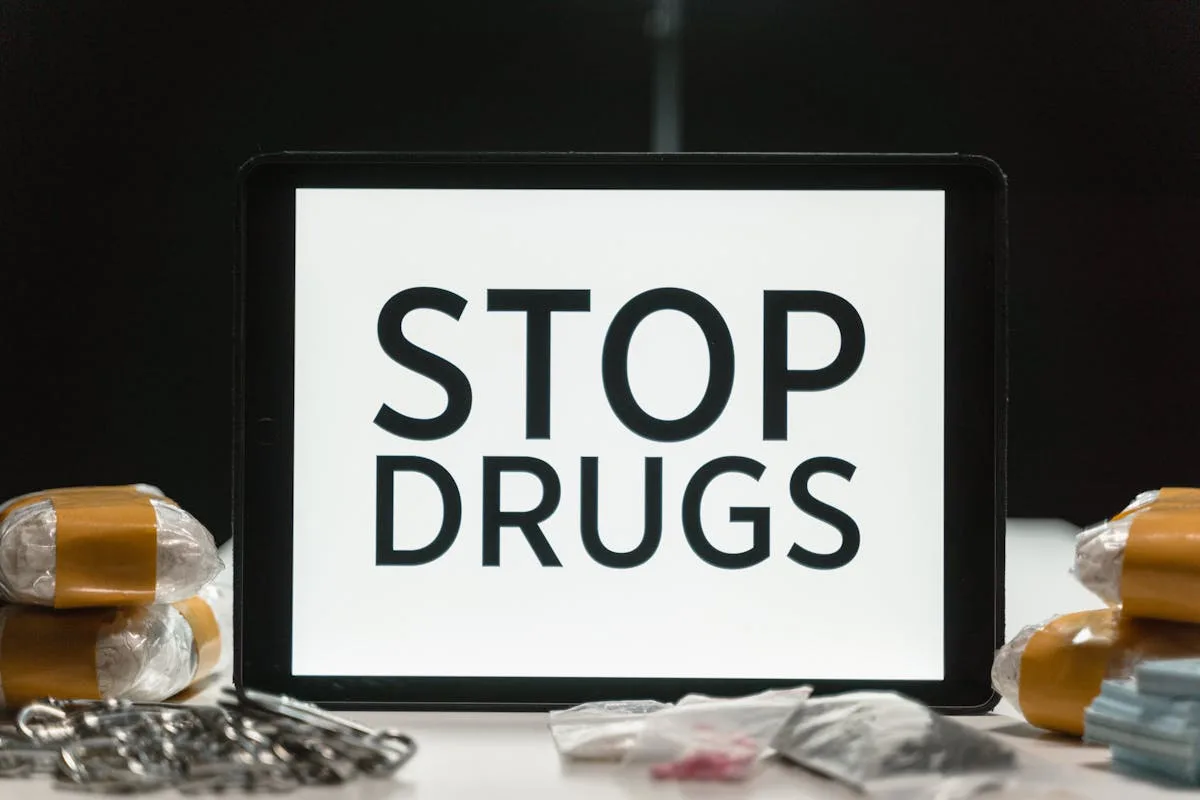 Tablet screen displaying anti-drug message surrounded by packaged substances, promoting awareness.
