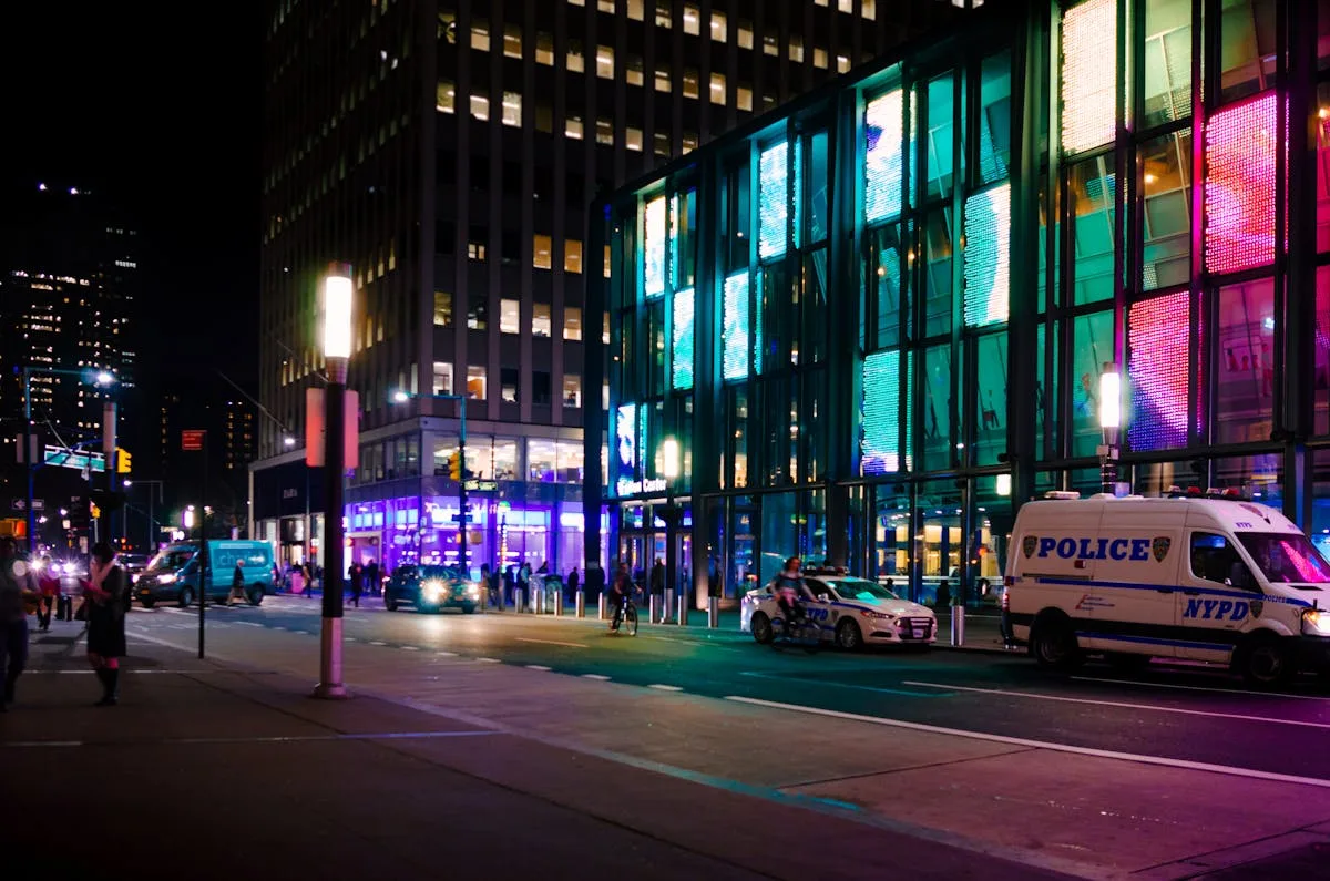 Vivid night scene showcasing city lights, police presence, and vibrant urban life.
