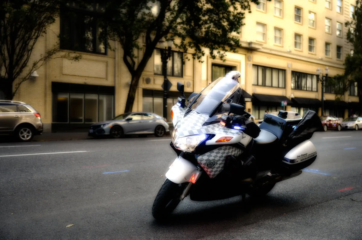 A police motorcycle stands on a city street, emphasizing urban safety and law enforcement.
