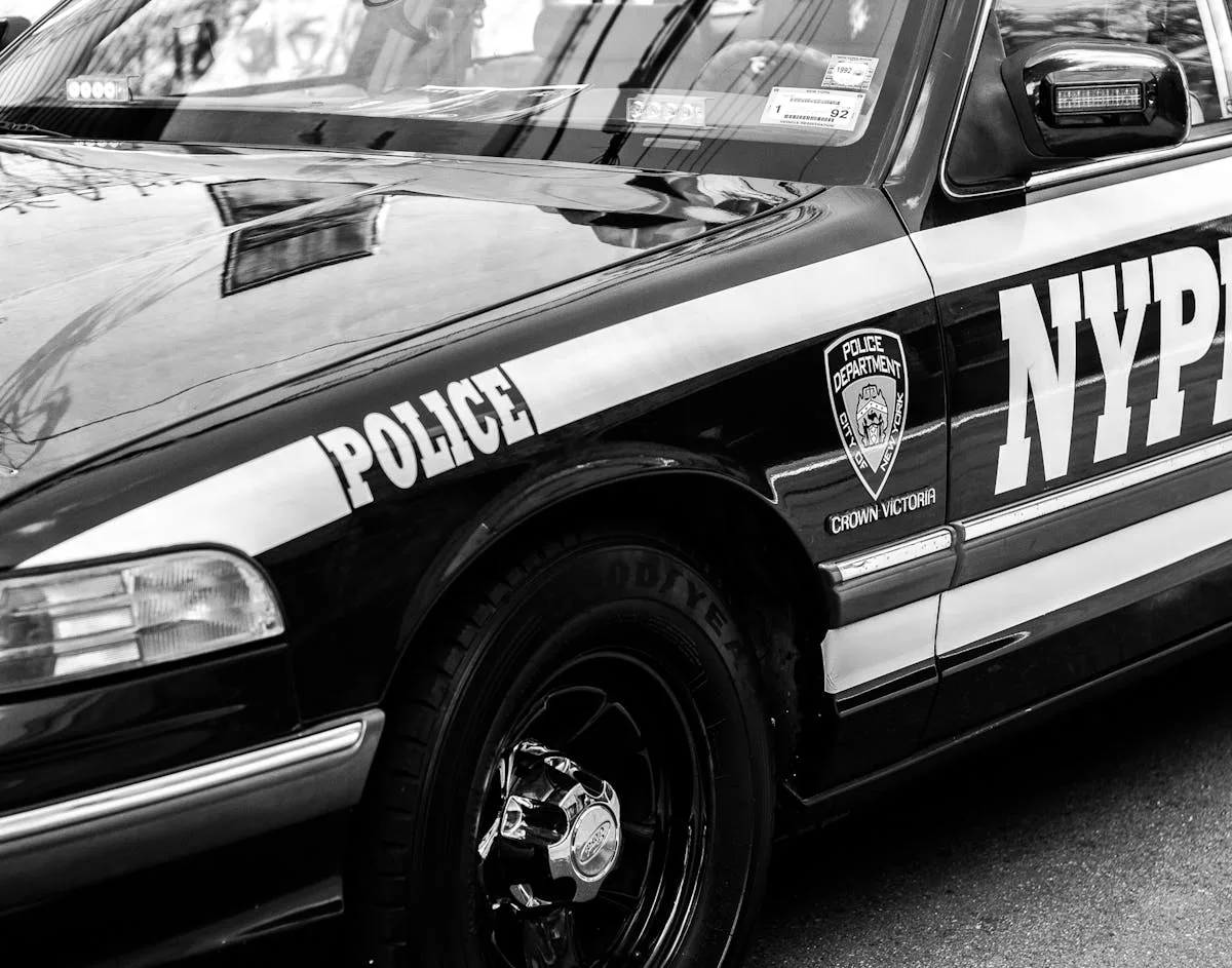 Classic NYPD police car captured on the street in black and white, highlighting urban law enforcement.