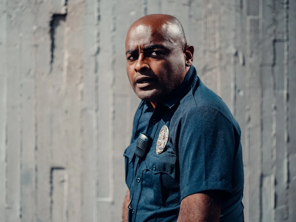 A dedicated police officer in uniform looking attentively outdoors, conveying dedication and professionalism.