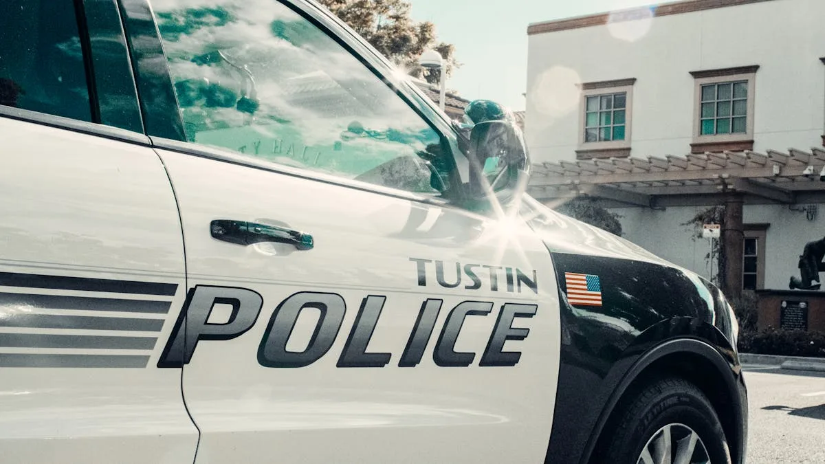Close-up of a Tustin police car parked near a city hall building in daylight.