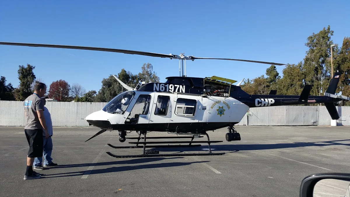 Police helicopter on display with officers standing beside it in an outdoor setting.
